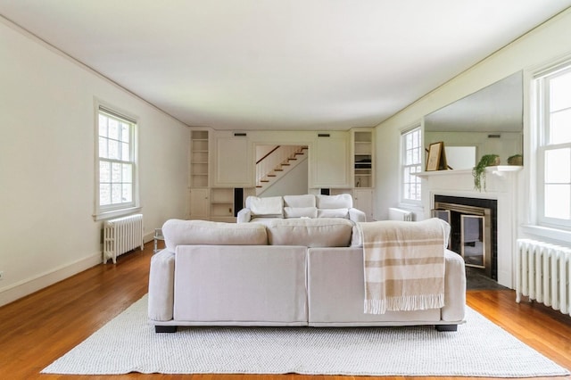 50 Overlook Dr, Chappaqua, NY 10514 - living area with radiator heating unit, wood finished floors, a fireplace with flush hearth, and stairway