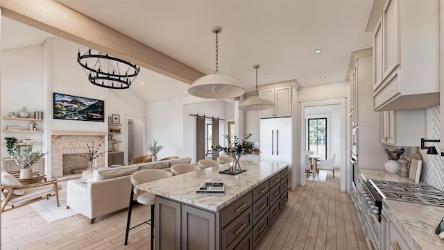 14 Akindale Rd, Pawling, NY 12564 - kitchen with a breakfast bar, a kitchen island, light stone counters, light wood finished floors, and pendant lighting