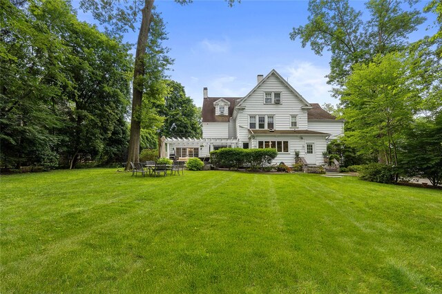121 Overlook Cir, New Rochelle, NY 10804 - back of house featuring a lawn, a pergola, and a chimney