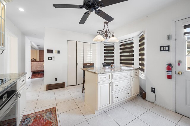 427 Benito St, East Meadow, NY 11554 - kitchen featuring stainless steel oven, recessed lighting, a ceiling fan, pendant lighting, and light tile patterned floors