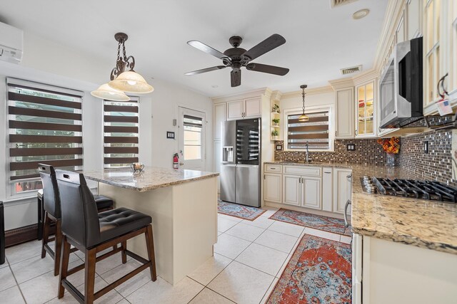 427 Benito St, East Meadow, NY 11554 - kitchen featuring cream cabinets, appliances with stainless steel finishes, backsplash, and a ceiling fan