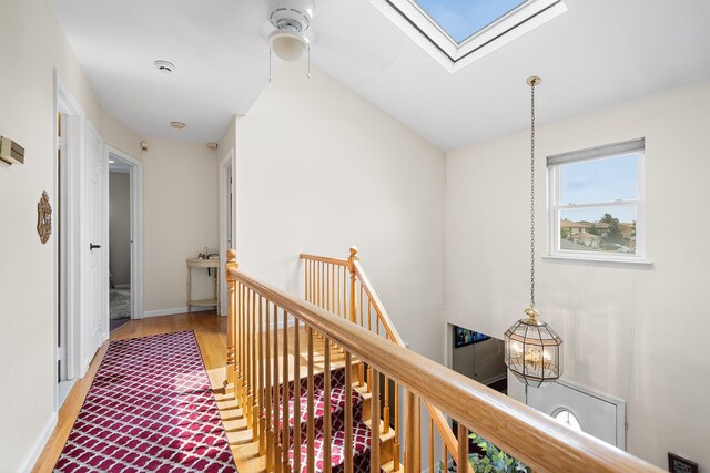 427 Benito St, East Meadow, NY 11554 - hallway with a skylight, an upstairs landing, and wood finished floors