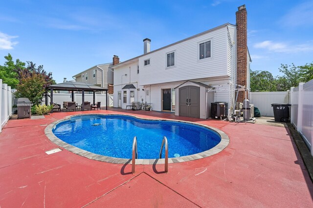 427 Benito St, East Meadow, NY 11554 - view of swimming pool with a gazebo, a patio, a storage unit, and a fenced backyard