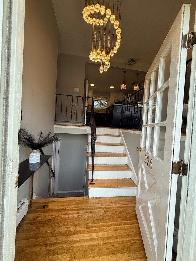226LAURIELANE Laurie Ln, West Hempstead, NY 11552 - stairway with a baseboard heating unit, wood finished floors, and a chandelier