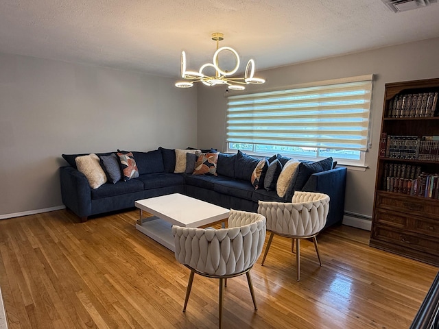 226LAURIELANE Laurie Ln, West Hempstead, NY 11552 - living area with wood finished floors, a chandelier, a baseboard heating unit, and a textured ceiling