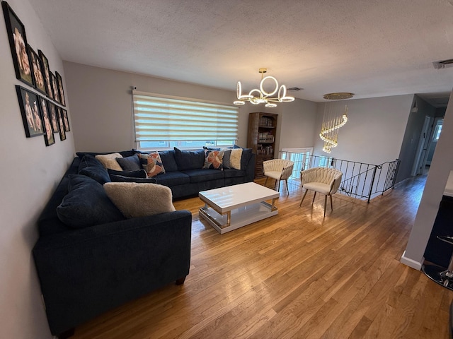 226LAURIELANE Laurie Ln, West Hempstead, NY 11552 - living room featuring a chandelier, a textured ceiling, and wood finished floors