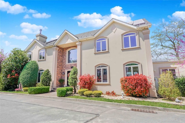 30 Aviva Ct, Staten Island, NY 10307 - view of front of home featuring stucco siding, solar panels, and a chimney