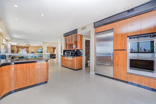 30 Aviva Ct, Staten Island, NY 10307 - kitchen featuring appliances with stainless steel finishes, dark countertops, glass insert cabinets, brown cabinetry, and open floor plan