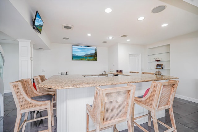 30 Aviva Ct, Staten Island, NY 10307 - kitchen with dark tile patterned flooring, light stone counters, recessed lighting, a kitchen bar, and a large island with sink