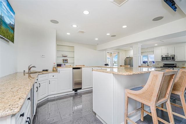 30 Aviva Ct, Staten Island, NY 10307 - kitchen with appliances with stainless steel finishes, recessed lighting, light stone counters, white cabinetry, and a kitchen island