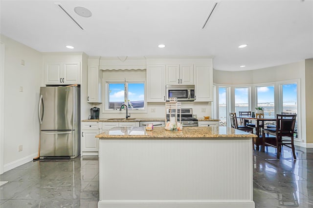 30 Aviva Ct, Staten Island, NY 10307 - kitchen featuring appliances with stainless steel finishes, a kitchen island, white cabinets, light stone countertops, and recessed lighting