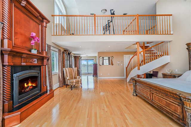 30 Aviva Ct, Staten Island, NY 10307 - living room featuring stairway, light wood finished floors, a warm lit fireplace, and a towering ceiling