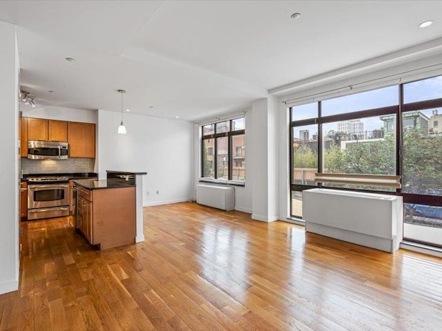 14 Hope St Unit 3F, Brooklyn, NY 11211 - kitchen with appliances with stainless steel finishes, brown cabinets, plenty of natural light, open floor plan, and recessed lighting