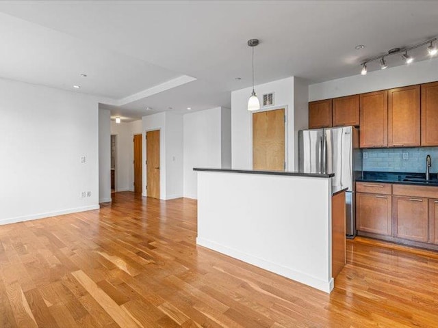 14 Hope St Unit 3F, Brooklyn, NY 11211 - kitchen featuring freestanding refrigerator, dark countertops, light wood finished floors, brown cabinetry, and backsplash