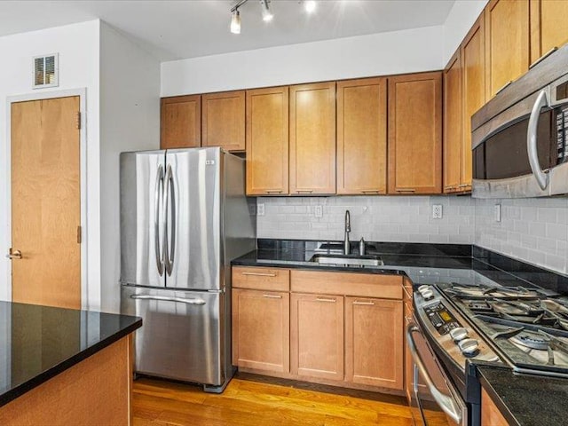 14 Hope St Unit 3F, Brooklyn, NY 11211 - kitchen with appliances with stainless steel finishes, light wood finished floors, brown cabinetry, and backsplash