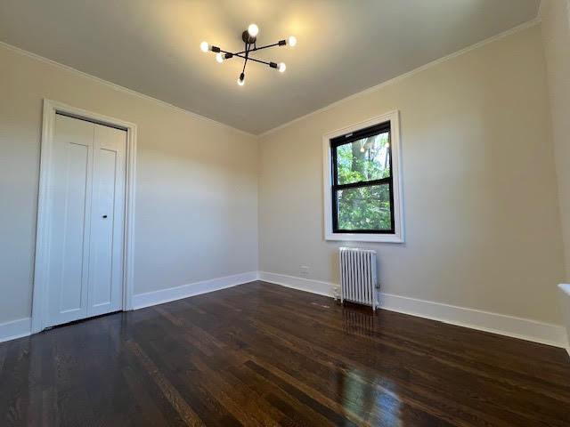 4118 Hill Ave, Bronx, NY 10466 - unfurnished room featuring radiator heating unit, crown molding, a chandelier, and dark wood-style floors