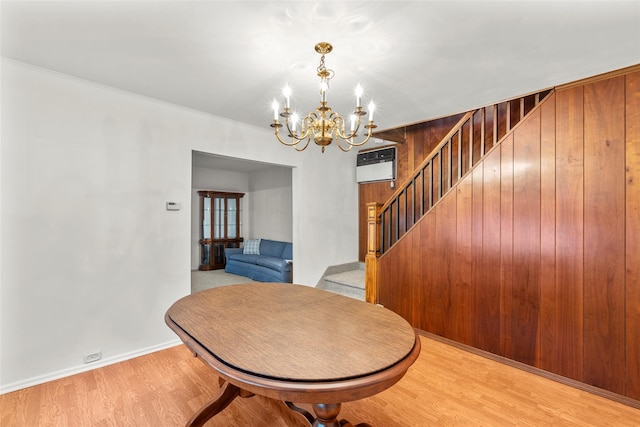 72 Putnam Ave, Valley Stream, NY 11580 - dining space featuring stairway, a chandelier, a wall mounted AC, light wood-style floors, and wooden walls