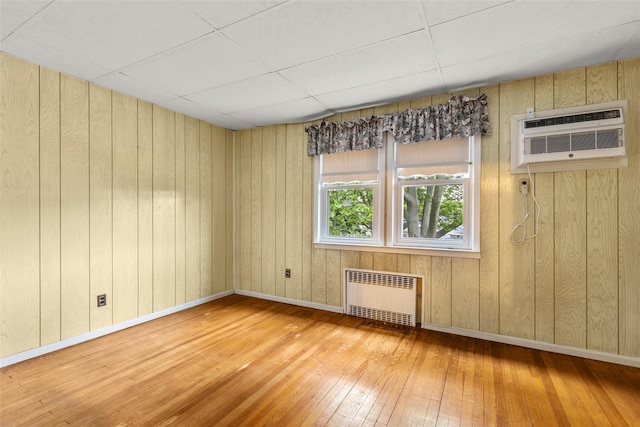 72 Putnam Ave, Valley Stream, NY 11580 - unfurnished room featuring radiator, hardwood / wood-style floors, wood walls, and a wall unit AC