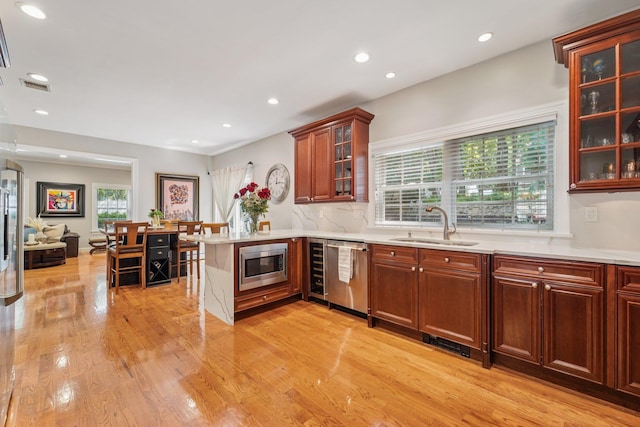 10 Willow Dr, Suffern, NY 10901 - kitchen with dishwasher, stainless steel microwave, a peninsula, light wood-style floors, and light countertops