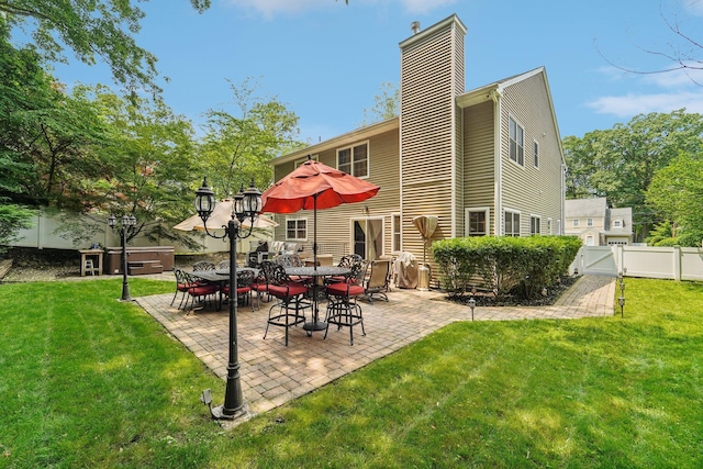 10 Willow Dr, Suffern, NY 10901 - rear view of house featuring a chimney, a fenced backyard, a gate, a patio area, and a hot tub
