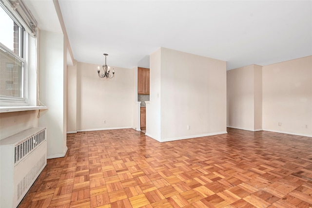 33 Barker Ave Unit 6K, White Plains, NY 10601 - unfurnished living room featuring radiator and a chandelier