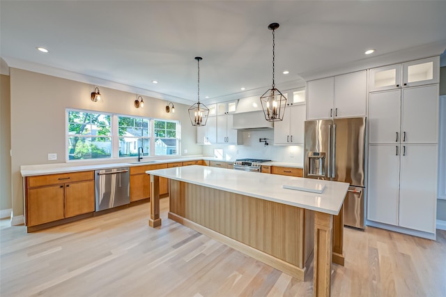 100 Root Ave, Islip, NY 11751 - kitchen with premium appliances, custom range hood, light wood-type flooring, light countertops, and glass insert cabinets