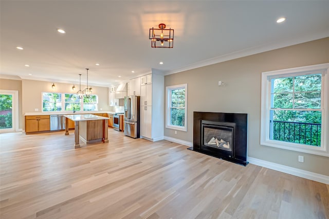 100 Root Ave, Islip, NY 11751 - kitchen with appliances with stainless steel finishes, light countertops, recessed lighting, a glass covered fireplace, and a kitchen island