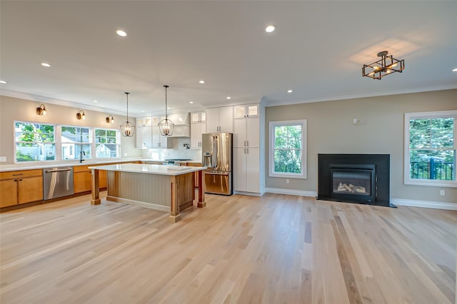 100 Root Ave, Islip, NY 11751 - kitchen featuring appliances with stainless steel finishes, light countertops, recessed lighting, a center island, and a fireplace with flush hearth