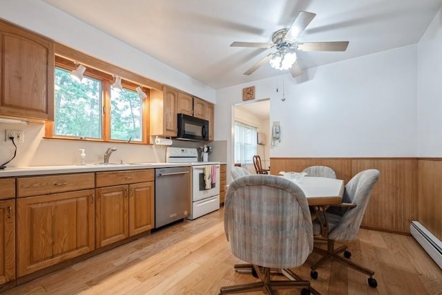 1581 Shirley Ct, North Merrick, NY 11566 - kitchen with stainless steel dishwasher, black microwave, white range with electric stovetop, baseboard heating, and wainscoting