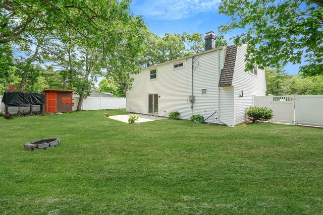 5439 Expressway Dr N, Holtsville, NY 11742 - back of property featuring a fire pit, a patio, a fenced backyard, and a chimney