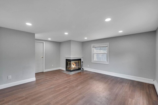 5439 Expressway Dr N, Holtsville, NY 11742 - unfurnished living room featuring wood finished floors, a multi sided fireplace, and recessed lighting