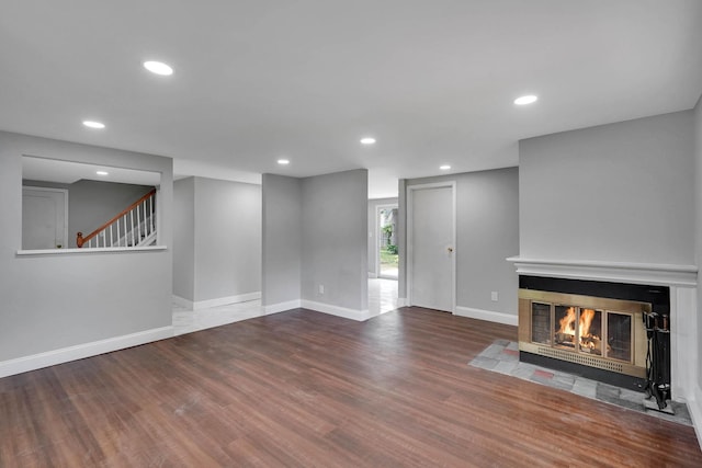 5439 Expressway Dr N, Holtsville, NY 11742 - unfurnished living room featuring a fireplace with flush hearth, wood finished floors, recessed lighting, and stairs