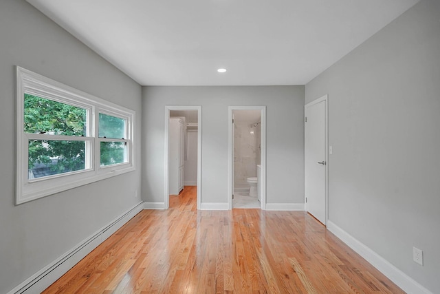 5439 Expressway Dr N, Holtsville, NY 11742 - unfurnished bedroom with baseboard heating, light wood-style flooring, a spacious closet, recessed lighting, and connected bathroom