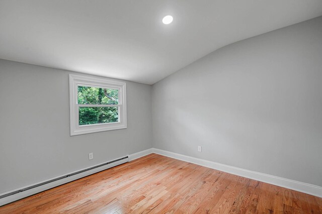 5439 Expressway Dr N, Holtsville, NY 11742 - unfurnished room with a baseboard radiator, vaulted ceiling, and light wood finished floors