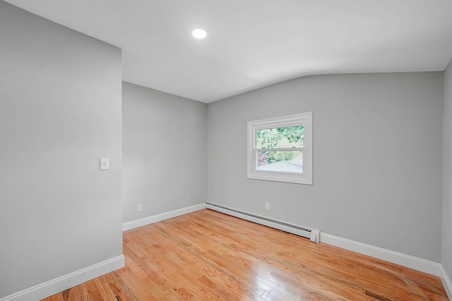 5439 Expressway Dr N, Holtsville, NY 11742 - spare room featuring a baseboard radiator, wood finished floors, vaulted ceiling, and recessed lighting