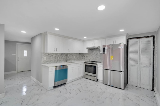 5439 Expressway Dr N, Holtsville, NY 11742 - kitchen featuring appliances with stainless steel finishes, light countertops, under cabinet range hood, light marble finish flooring, and white cabinetry