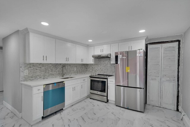 5439 Expressway Dr N, Holtsville, NY 11742 - kitchen with appliances with stainless steel finishes, under cabinet range hood, light marble finish floors, light countertops, and white cabinets
