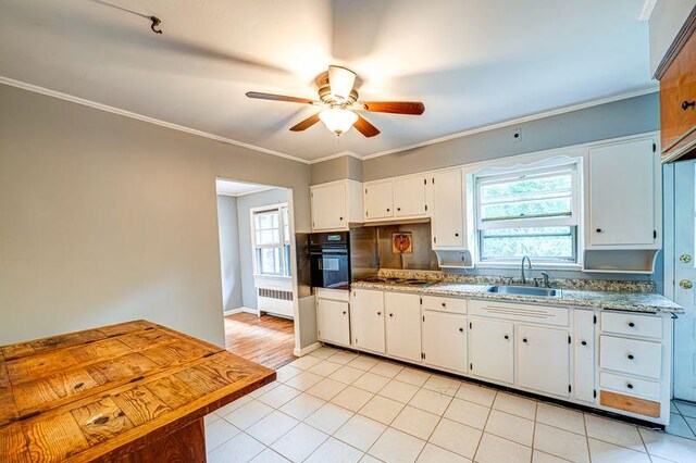 83 Bellerose Ave, East Northport, NY 11731 - kitchen with oven, radiator, a ceiling fan, white cabinets, and light tile patterned floors