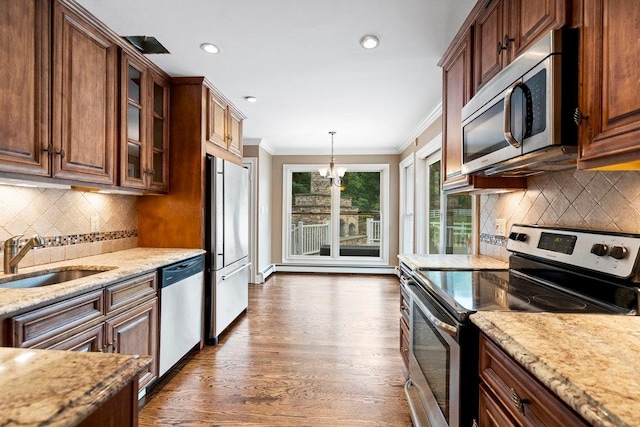 109 Oakside Dr, Smithtown, NY 11787 - kitchen with appliances with stainless steel finishes, ornamental molding, dark wood-type flooring, light stone countertops, and glass insert cabinets