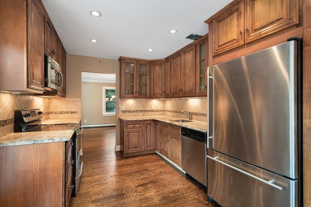 109 Oakside Dr, Smithtown, NY 11787 - kitchen with stainless steel appliances, recessed lighting, dark wood-style floors, decorative backsplash, and light stone counters