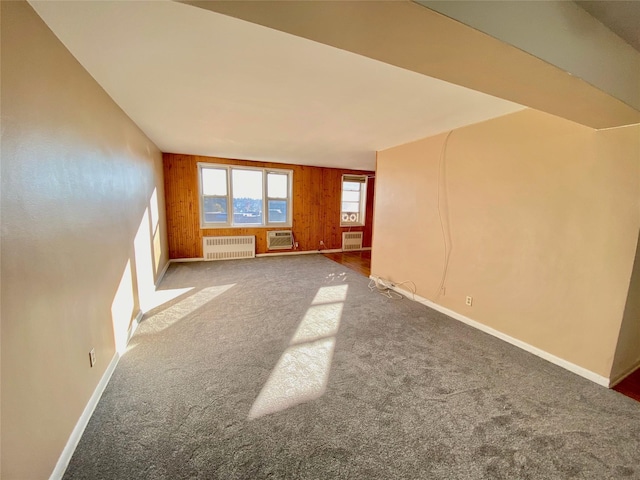 1 Sadore Ln Unit 7O, Yonkers, NY 10710 - carpeted empty room with radiator, wood walls, and a wall mounted AC