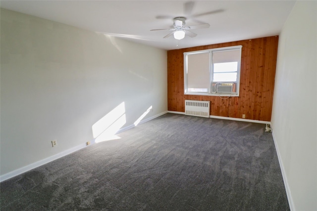 1 Sadore Ln Unit 7O, Yonkers, NY 10710 - spare room featuring radiator heating unit, dark colored carpet, cooling unit, ceiling fan, and wood walls