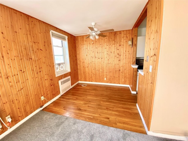 1 Sadore Ln Unit 7O, Yonkers, NY 10710 - empty room with radiator, a ceiling fan, wood walls, and wood finished floors