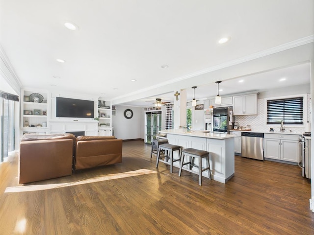 554 S 8th St, Lindenhurst, NY 11757 - living room featuring plenty of natural light, dark wood finished floors, crown molding, ceiling fan, and recessed lighting