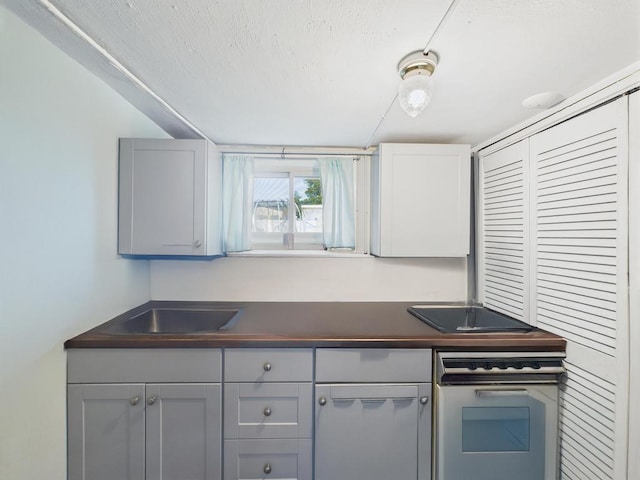 554 S 8th St, Lindenhurst, NY 11757 - kitchen featuring oven, dark countertops, and gray cabinetry