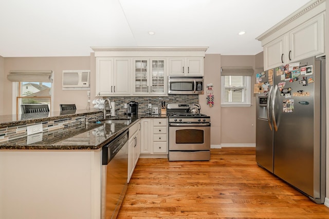 40 Syracuse St, Williston Park, NY 11596 - kitchen with appliances with stainless steel finishes, a peninsula, light wood-style flooring, decorative backsplash, and a wall unit AC