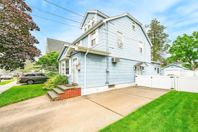 40 Syracuse St, Williston Park, NY 11596 - view of home's exterior with a gate, a wall mounted air conditioner, cooling unit, and a patio