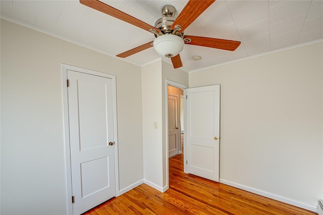 926 9th St, West Babylon, NY 11704 - unfurnished bedroom with light wood finished floors, ornamental molding, ceiling fan, and a baseboard radiator