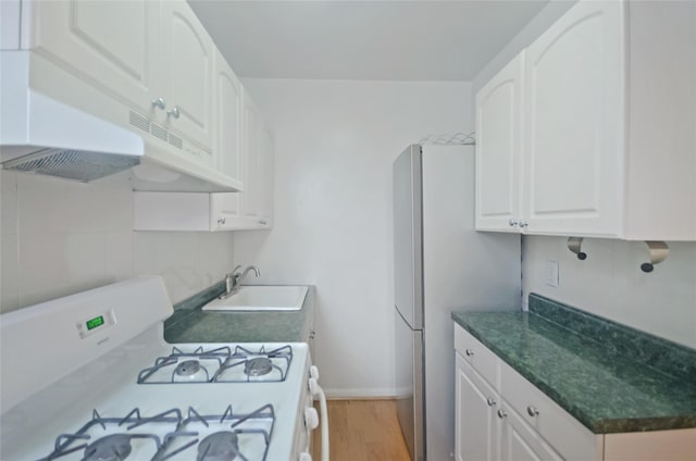790 Bronx River Rd Unit A31, Bronxville, NY 10708 - kitchen with white range with gas cooktop, light wood finished floors, white cabinets, and freestanding refrigerator
