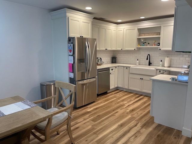 892 Skyline Dr Unit 892, Coram, NY 11727 - kitchen featuring appliances with stainless steel finishes, light wood finished floors, light countertops, decorative backsplash, and open shelves